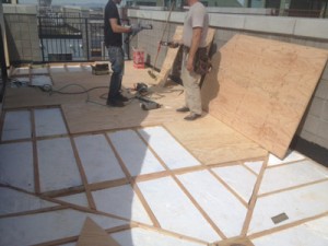 Preparing the roof deck substrate for the application of Duradek vinyl.