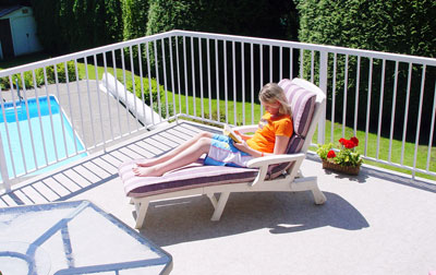 Girl lounging and reading on a Duradek deck.