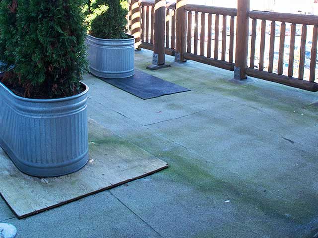 Plywood and mats used on rooftop patio with leaks requiring repair & renovation