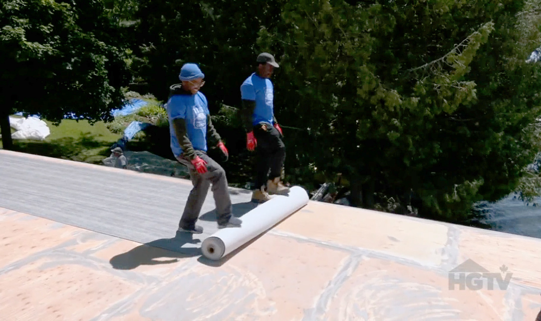 Duradek applicators roll out the Duradek vinyl waterproof membrane in the boathouse roof deck renovation.